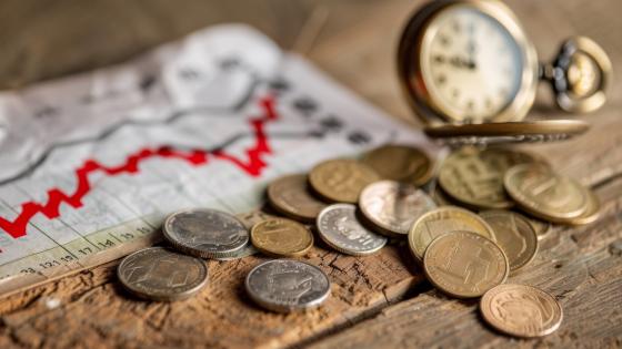 Old coins, graph and pocket watch