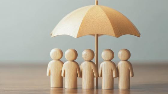 Wooden people under umbrella